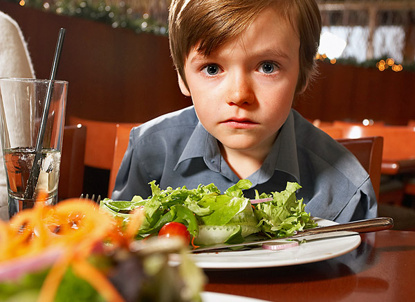 Junge mit Autismus, der in einem Restaurant isst