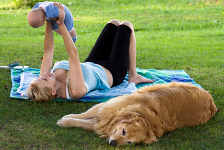 Frau mit Neugeborenen und Hund