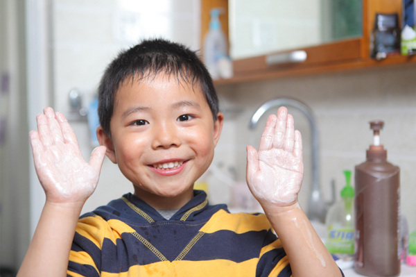 Mały chłopiec myje ręce w domu