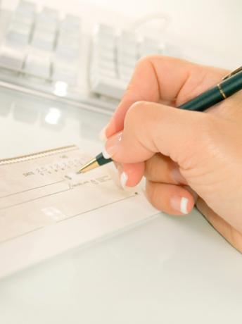 Kobieta pisząca czek przed klawiaturą