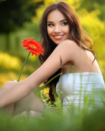 Nasmejana mlada ženska, ki uživa v pomladi