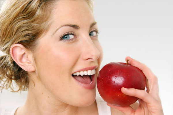 здорова жінка їсть яблуко