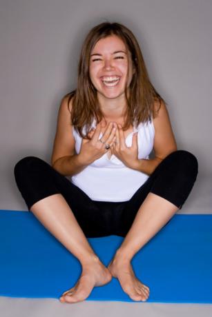 Mujer riendo mientras hace yoga