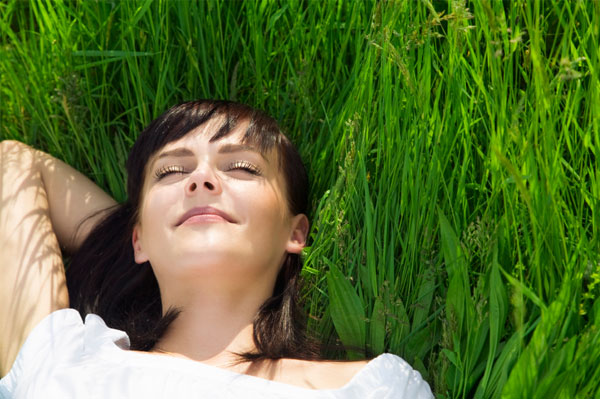 Svobodná žena relaxující v trávě