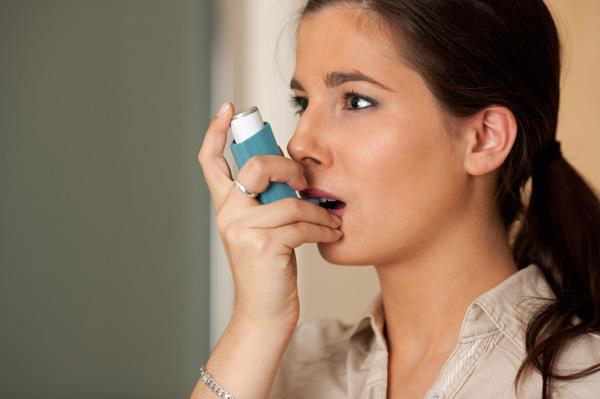 Femme avec inhalateur d'asthme