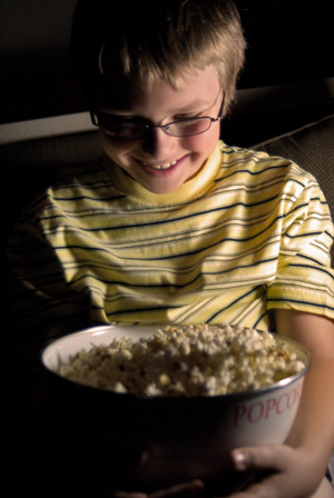 Chłopiec je popcorn