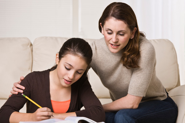 Mãe com filha adolescente fazendo lição de casa