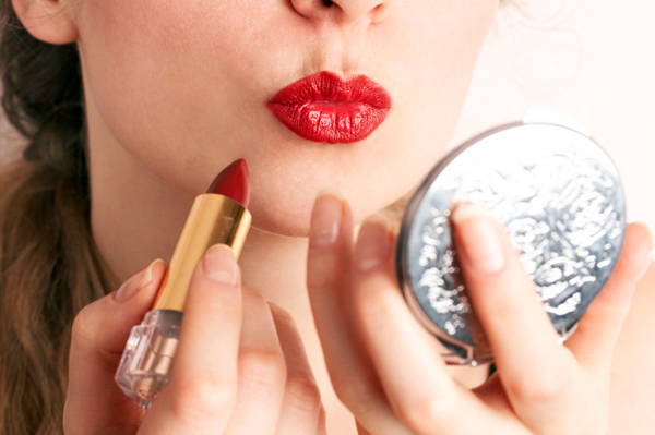 Vrouw die gewaagde rode lippenstift toepast