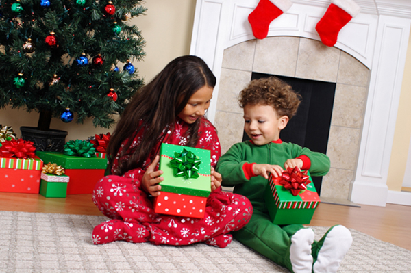 Dzieci otwierające prezenty świąteczne