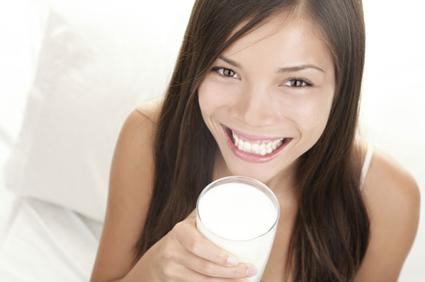 Jonge vrouw die melk drinkt