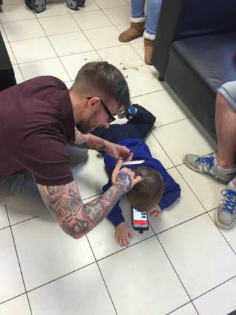 Peluquero corta el cabello de un niño autista