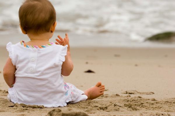 해변에 앉아 있는 아기
