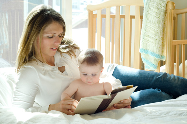 Wanita membaca untuk bayi