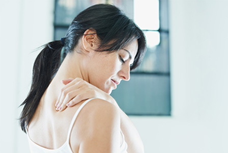 Kvinde med smerter i øvre ryg