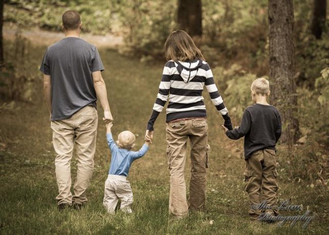 Perhe kävelee käsi kädessä