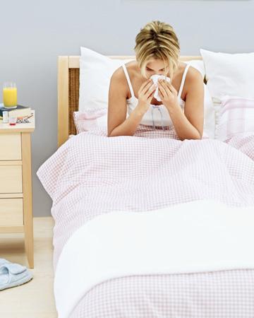 Žena v posteli s chřipkou