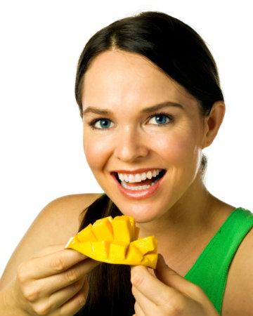 Mujer feliz comiendo mango