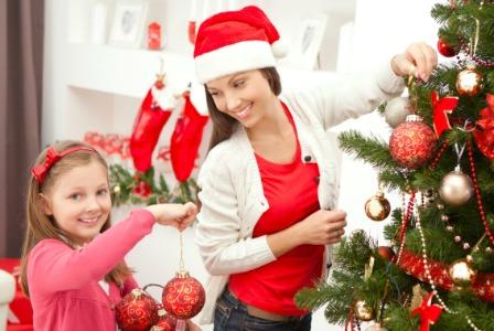 Mama und Tochter schmücken den Weihnachtsbaum