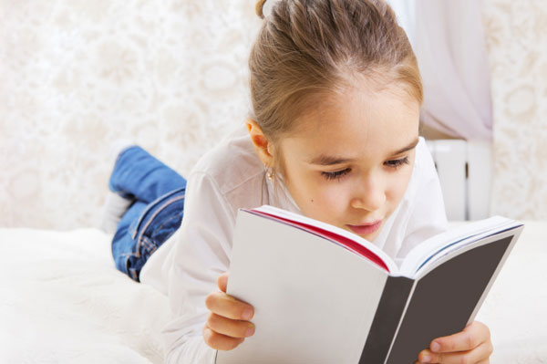 Mädchen liest Buch auf dem Bett | Sheknows.ca