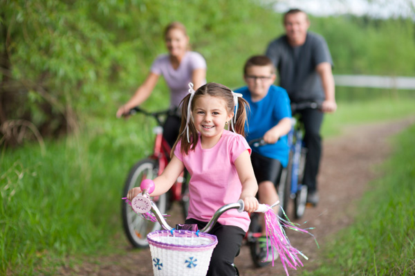 Lány kerékpározás a családdal