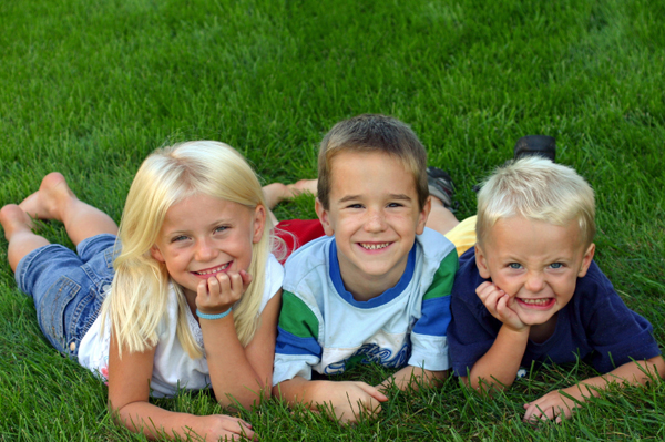 أطفال يلعبون في العشب في الصيف