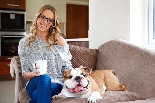 Frau mit Bulldogge auf der Couch