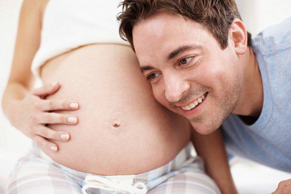 aufgeregter zukünftiger Vater mit schwangerer Frau
