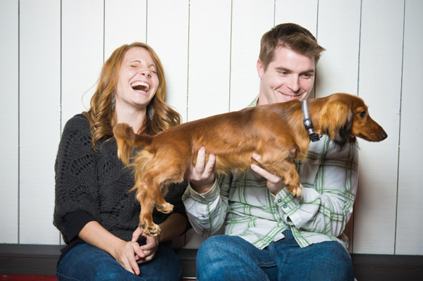Casal rindo com cachorro