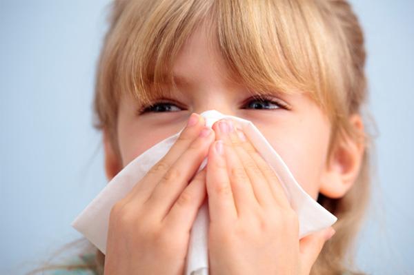Dívka kýchání během chřipkové sezóny