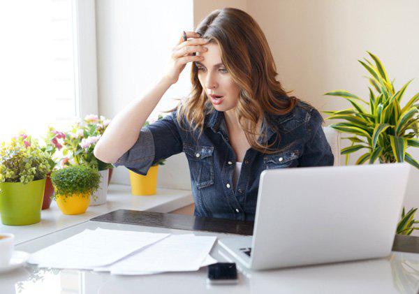 Frau am PC mit finanziellen Problemen