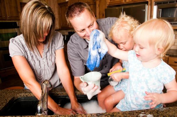 семья вместе мыть посуду на современной кухне