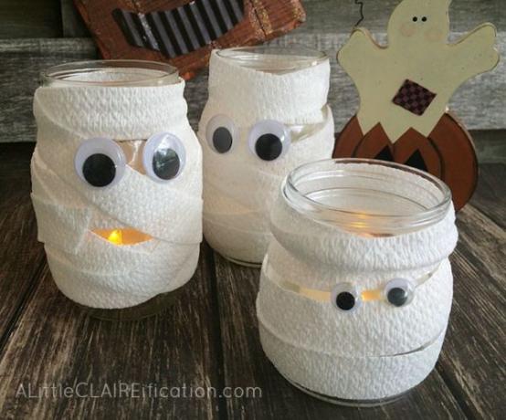 9 งานฝีมือฮัลโลวีนที่น่ารักสุด ๆ โดยไม่ต้องวิเศษ: Mummy Mason Jar Luminaries