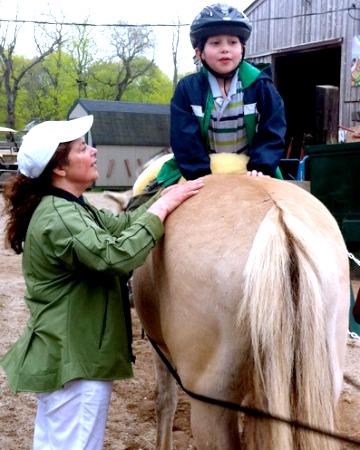 Junge auf dem Pferd - Hippotherapie-Behandlung