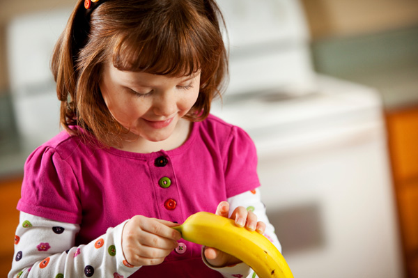 Девушка чистит банан
