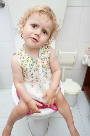 maza meitene, kas izmanto tualeti