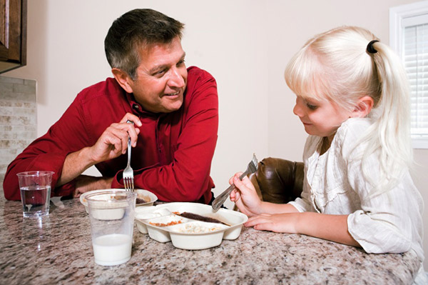 Vater und Tochter essen gefrorenes Abendessen