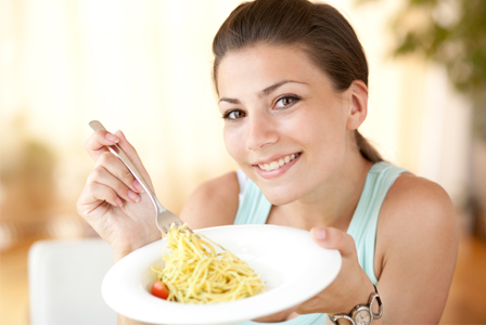 Wanita makan pasta