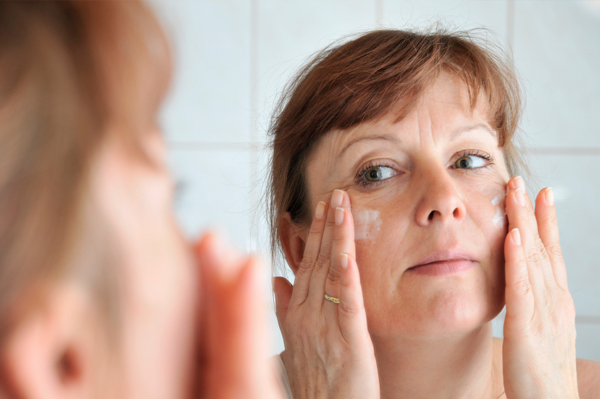 Mujer aplicando crema hidratante para pieles maduras