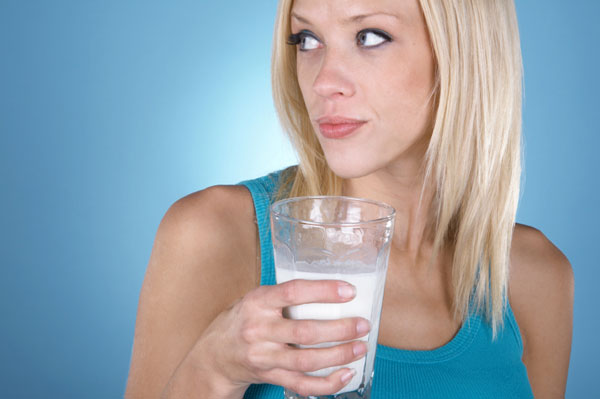 Жінка п'є молоко