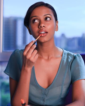 Mujer aplicando brillo de labios
