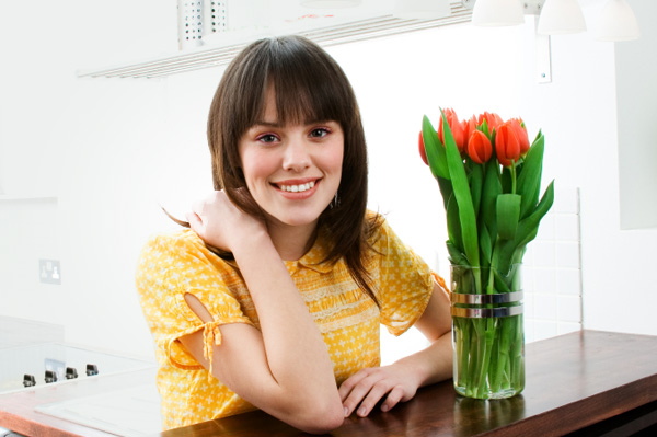 жінка з вазою з квітами