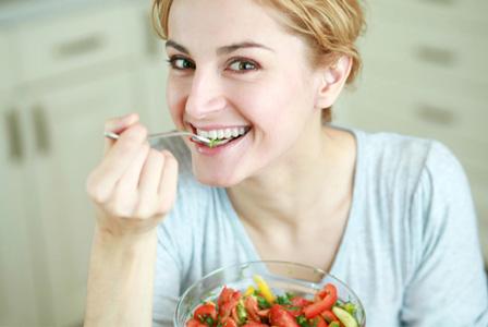 Щастлива жена яде DASH диетично хранене