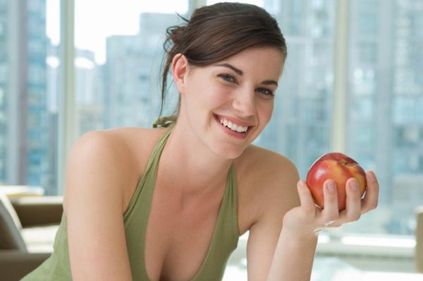 امرأة تحمل تفاحة