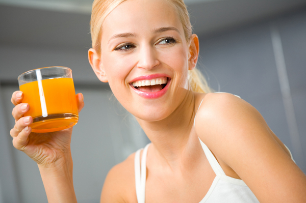 Žena pije pomerančový džus