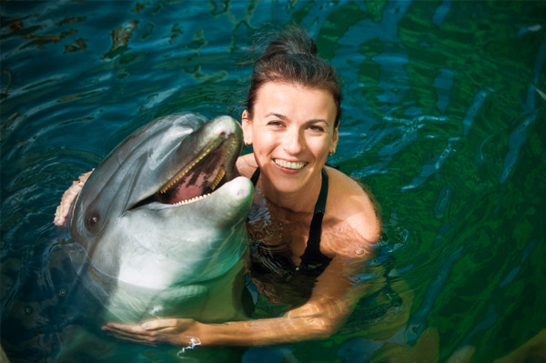 Sieviete peld ar delfīniem