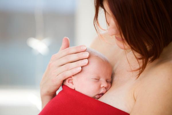 Mama z novorojenčkom v rdeči barvi