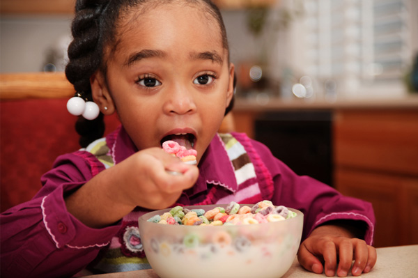 Fată care mănâncă cereale de zahăr