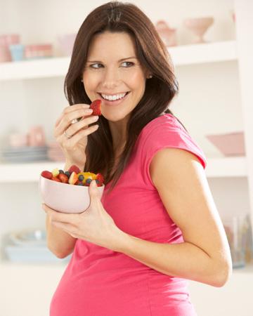 terhes nő gyümölcsöt eszik