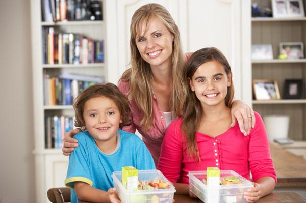 Madre e hijos con almuerzos saludables empaquetados