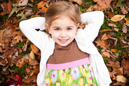 Kleines Mädchen, das im Herbst eine Strickjacke trägt